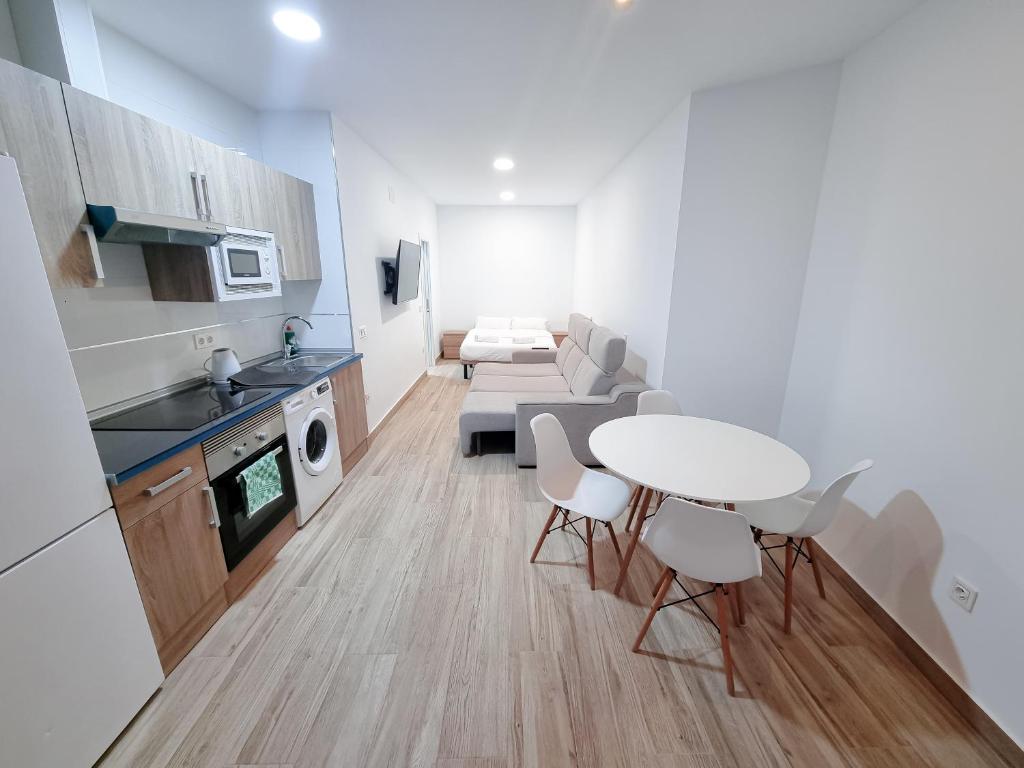 cocina y sala de estar con mesa y sillas en Metropolitan apartments, en Madrid