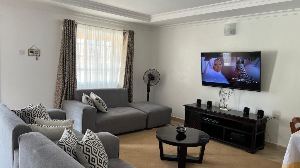 a living room with a couch and a flat screen tv at Dala Luxury Home- Bondo in Bondo