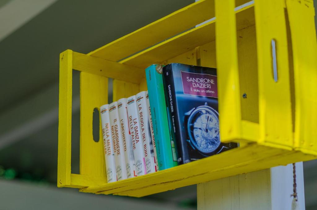 a row of books on a yellow shelf at B&B Tor Di Lupo in Mattinata