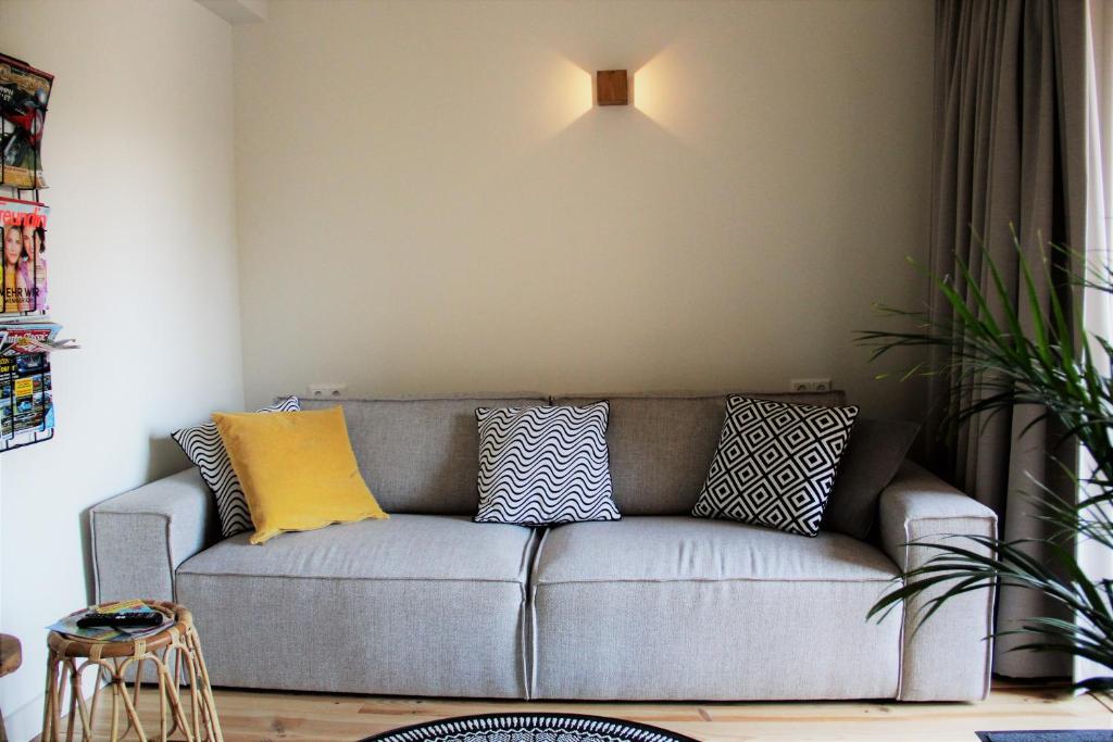 un soggiorno con divano e cuscini sopra di Southpoint Zandvoort with free parking a Zandvoort