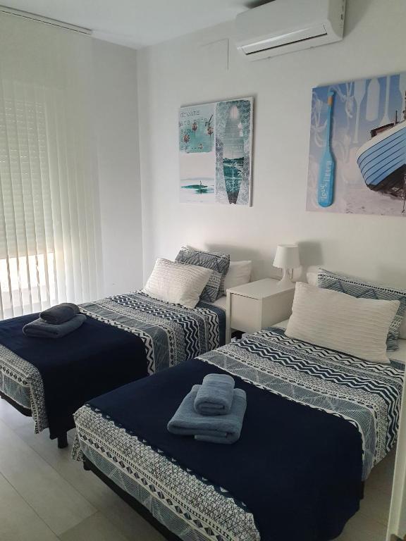 Pokój z 3 łóżkami z niebieską pościelą w obiekcie Paraiso w mieście Torrevieja