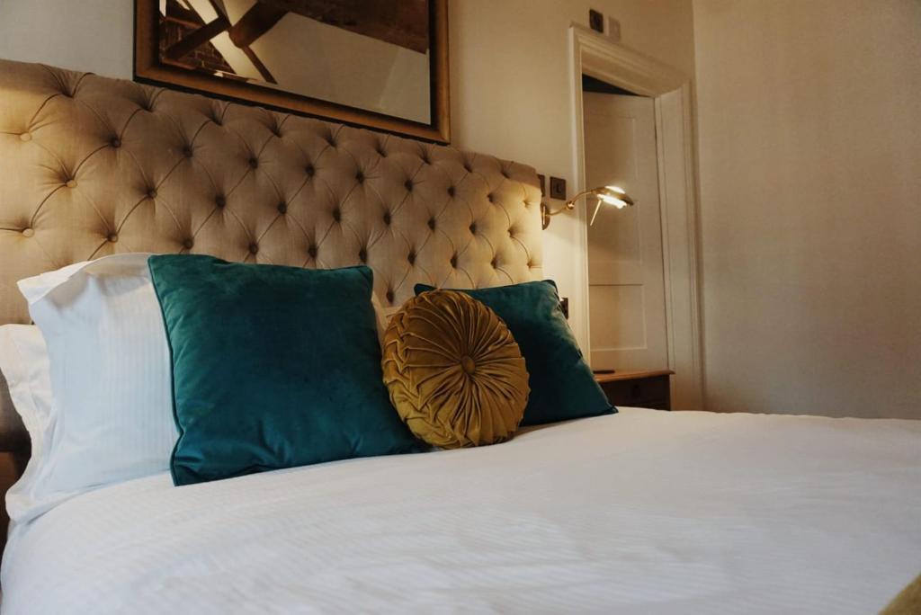 uma cama com almofadas verdes e brancas em Upstairs at 33 - Self check in boutique accommodation in Worcester Centre em Worcester