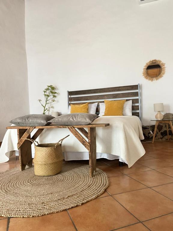 um quarto com uma cama com almofadas amarelas e uma mesa em Is Scabas Guestrooms em Solarussa