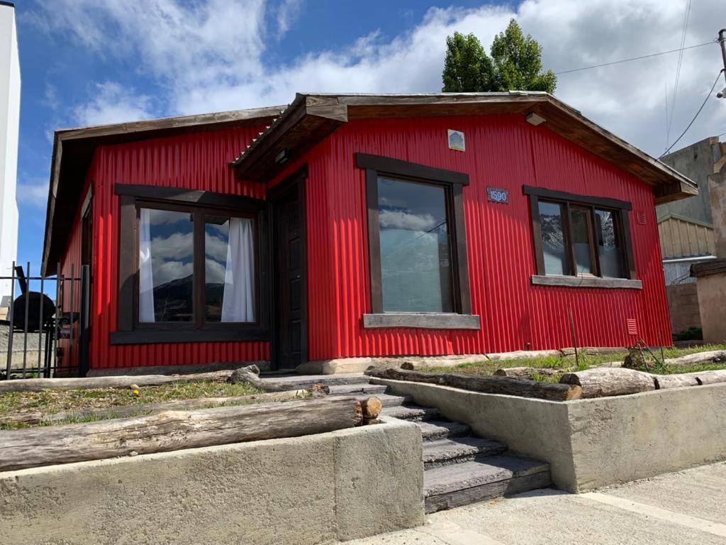 uma casa vermelha com janelas e escadas em frente em Casa Los Canelos em Ushuaia