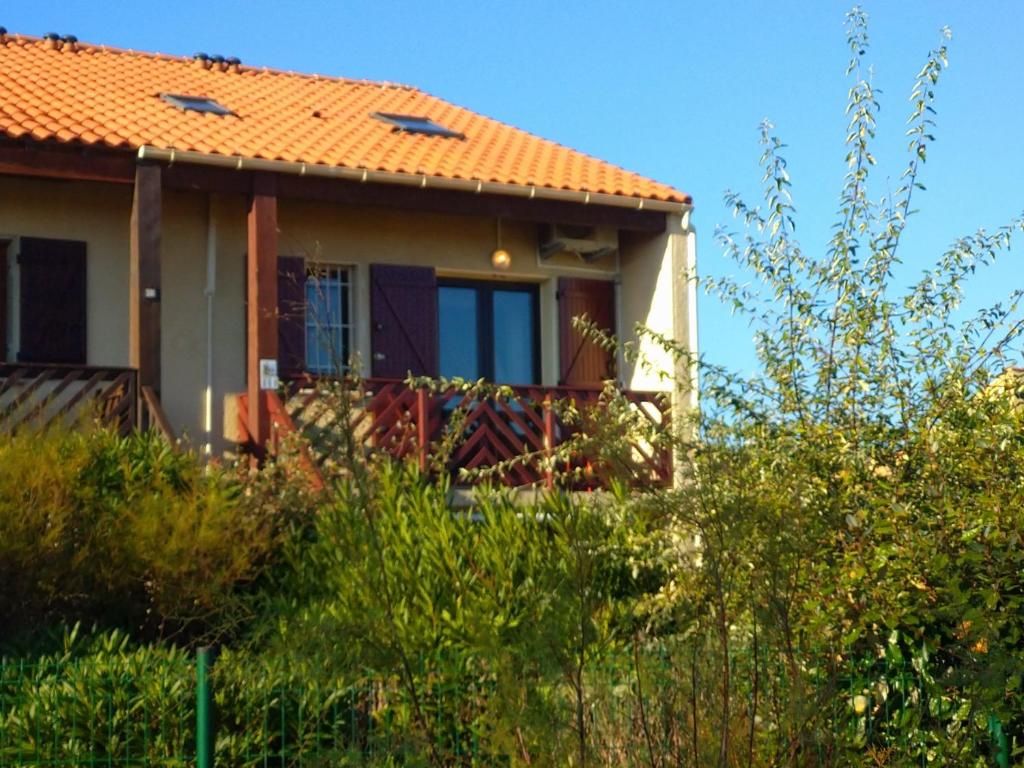 ein Haus mit einem orangenen Dach und einigen Büschen in der Unterkunft Appartement Port Rose 2 in Leucate