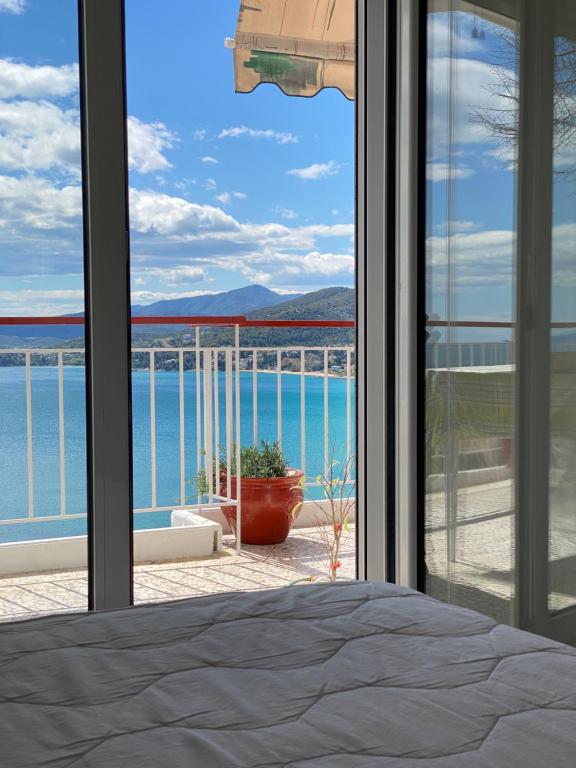 sypialnia z oknem z widokiem na ocean w obiekcie Mimoza's Sea View Apartment w mieście Palaión Tsiflíkion