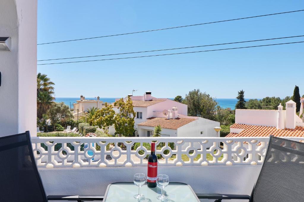 Una botella de vino sentada en una mesa en un balcón en Bela Vista Nr. 4, en Carvoeiro