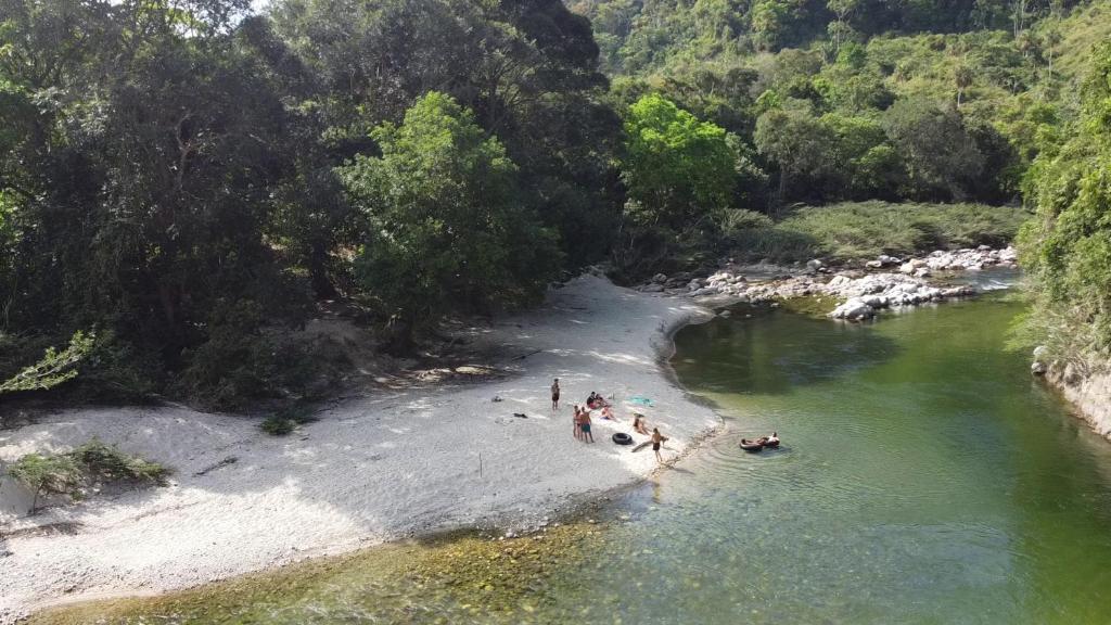 a group of people on a beach in a river at La Ponderosa Reserve in Buritaca