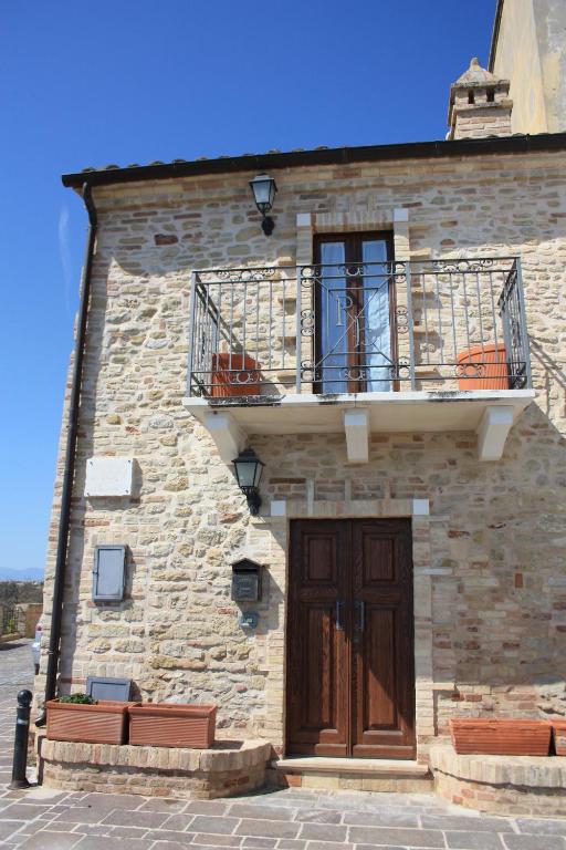 ein Backsteingebäude mit einem Balkon und einer Tür in der Unterkunft ANPEMO Casa Vacanze in Silvi Paese