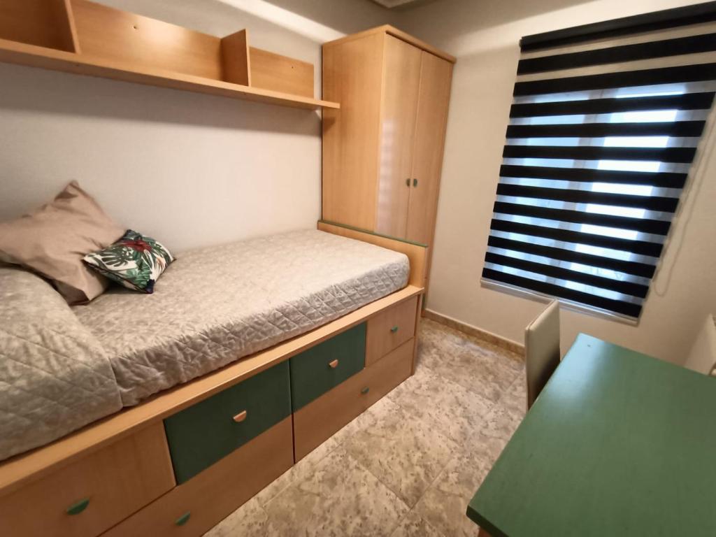 - une petite chambre avec un lit et une table dans l'établissement Luxury Family Homes K, à Salamanque