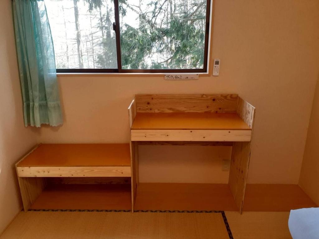 escritorio y banco en una habitación con ventana en Yasha Gami Hutte - Vacation STAY 36327v, en Minami Alps