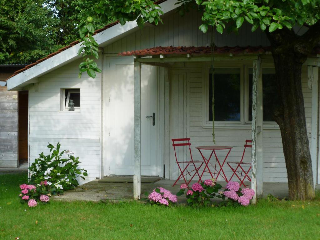 two chairs and a table in front of a house at LE CHALET de LA LONGERE in Beuvry-Nord