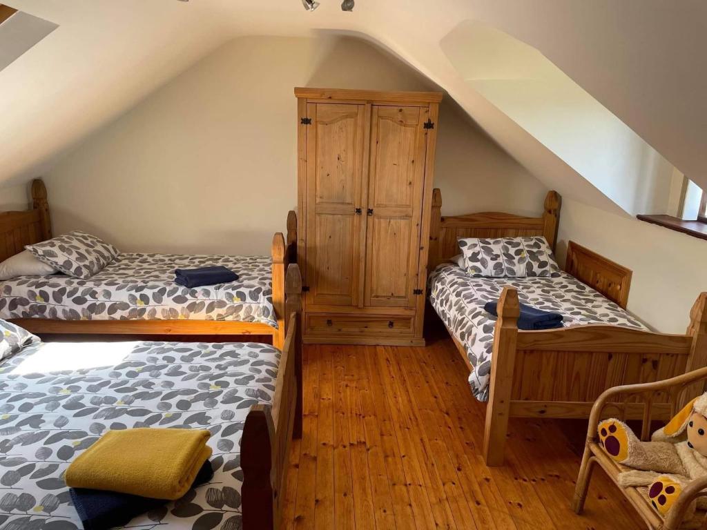 1 dormitorio en el ático con 2 camas y armario en Church View B&B, en Ballycastle