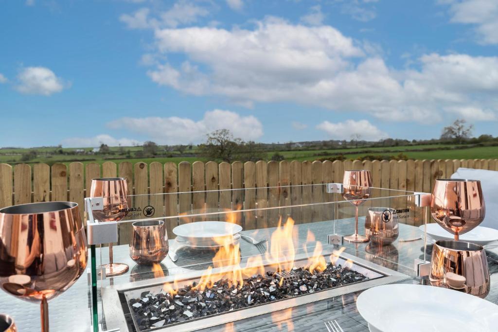 a glass table with a fire pit on a patio at The Hideaway @ Watergate eye Farm in Barnard Castle