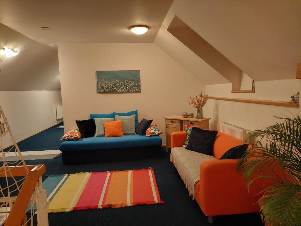 - un salon avec des canapés orange et bleu dans l'établissement Dvoupokojový apartmán s kuchyňským koutem, à Kutná Hora