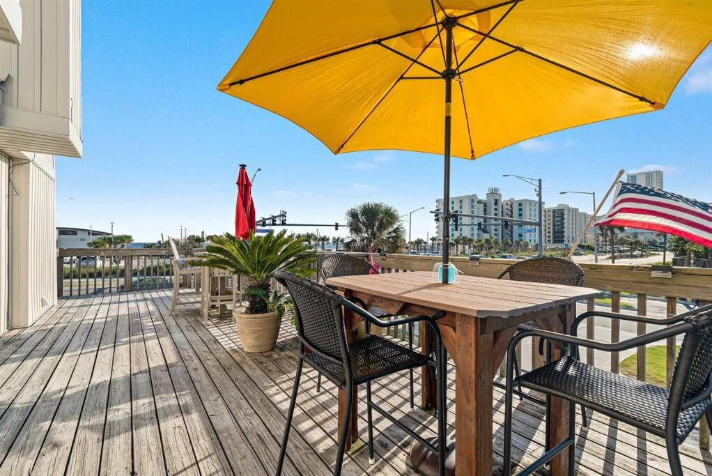 einem Holztisch mit gelbem Regenschirm auf dem Deck in der Unterkunft South Winds unit 2-Gorgeous Newly Updated Condo in the Heart of Gulf Shores!! in Gulf Shores