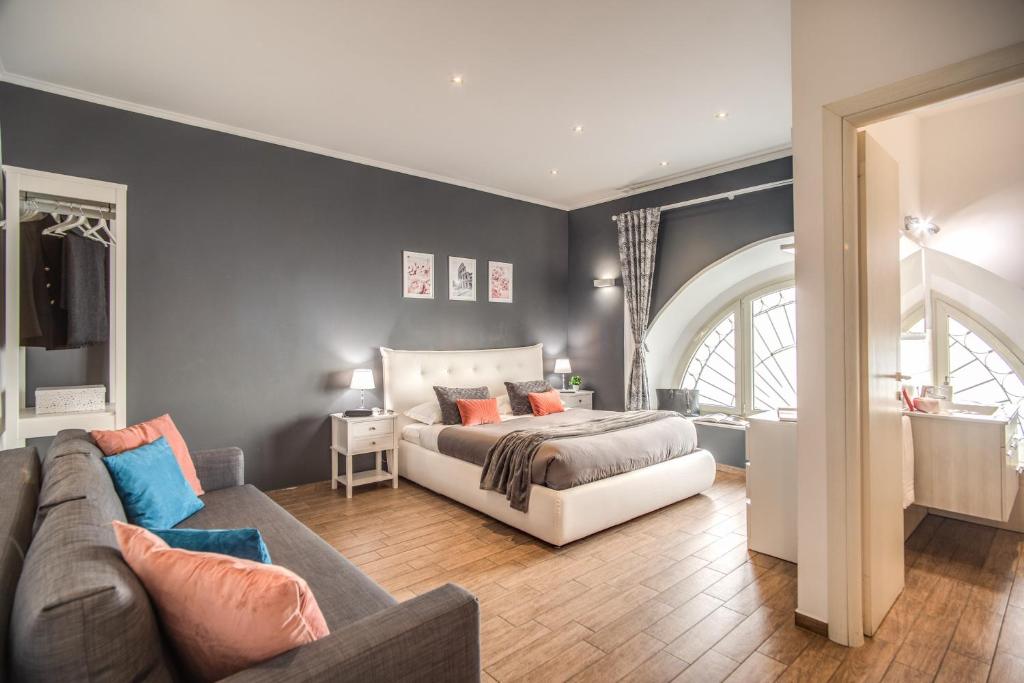 sypialnia z łóżkiem i kanapą w obiekcie Colosseum Royal Apartment w Rzymie