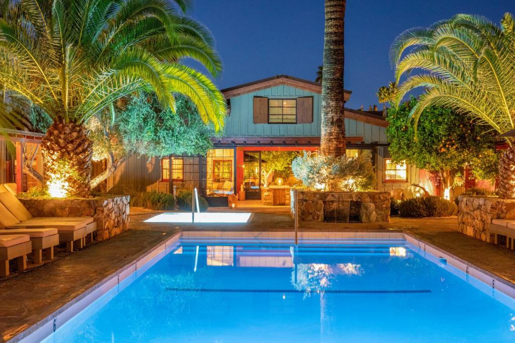 a house with a swimming pool and palm trees at Sparrows Lodge in Palm Springs