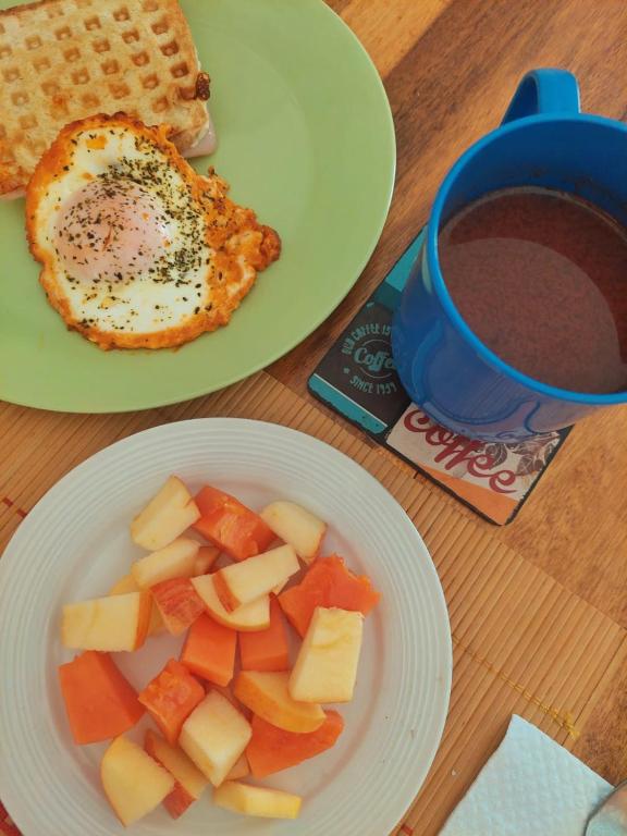 a table with two plates of food and a cup of coffee at Tatami Hostel in Bucaramanga