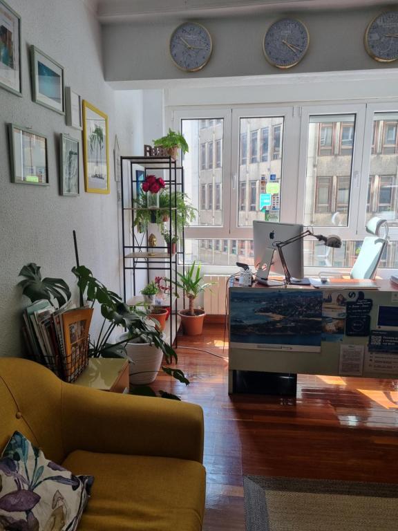 a living room filled with furniture and plants at Pension Angelines, Sneuu Hostel Santander in Santander