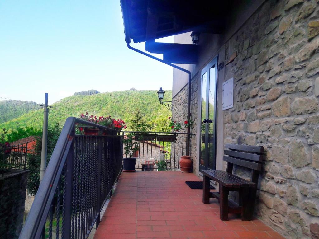 a balcony with a bench and a stone wall at Pratomagno Apartment in Cetica