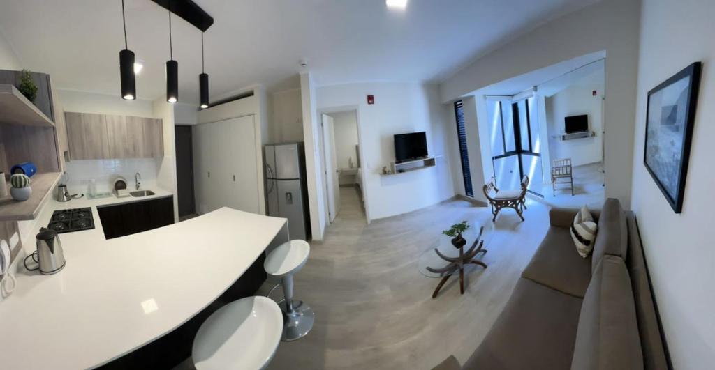 een keuken en een woonkamer met een wit aanrecht bij APARTMENT FULL EQUIP BARRANCO (BRAND NEW) in Lima