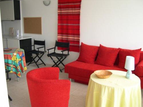 a living room with a red couch and chairs and a table at 6 Treti Mart street 2 floor in Primorsko