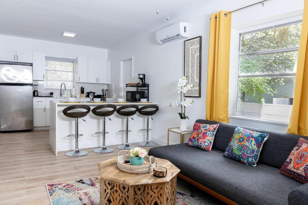 a living room with a couch and a kitchen at Beautiful Casita with King Bed and private patio Close to Calle 8, MIA Airport, Coral Gables in Miami