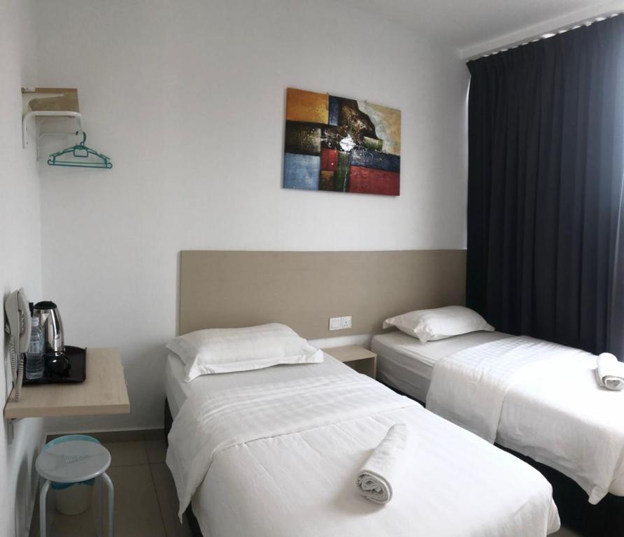 a hotel room with two beds and a table at M Design Hotel@KLIA,Sepang in Sepang