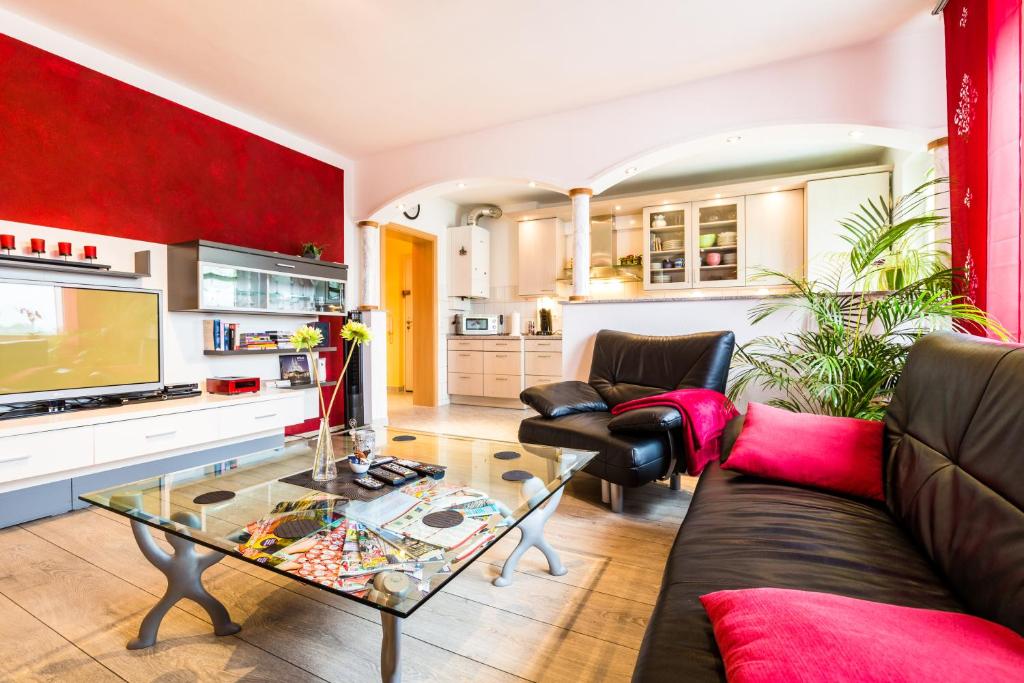 uma sala de estar com um sofá e uma mesa de vidro em Ferienwohnung Köln Messenähe em Colônia