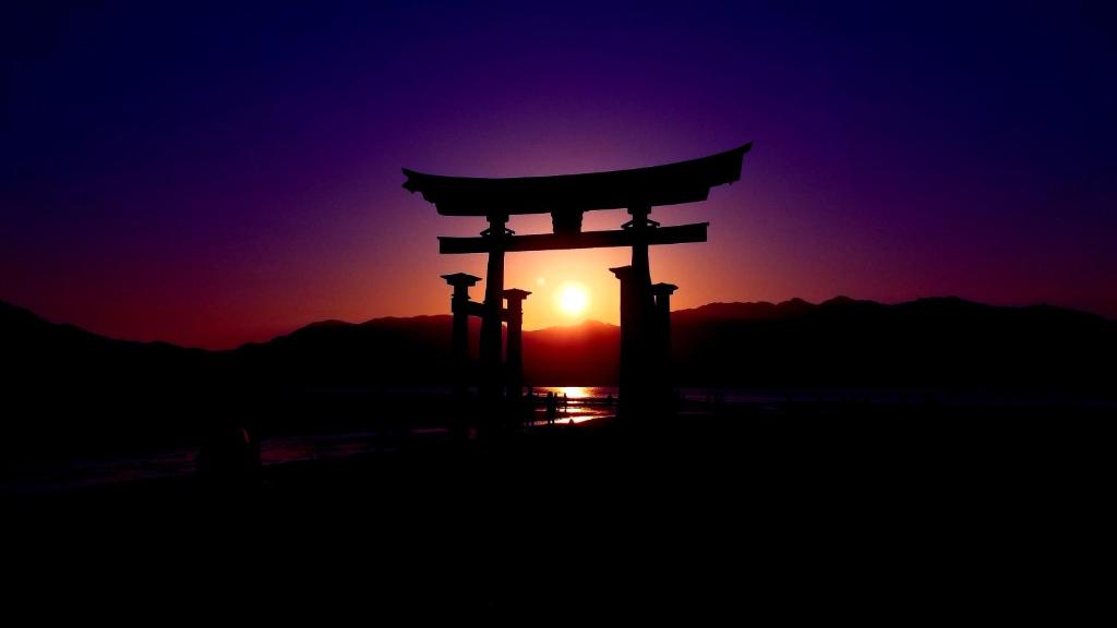 een Aziatische poort voor een zonsondergang bij Full house Miyajima in Miyajima