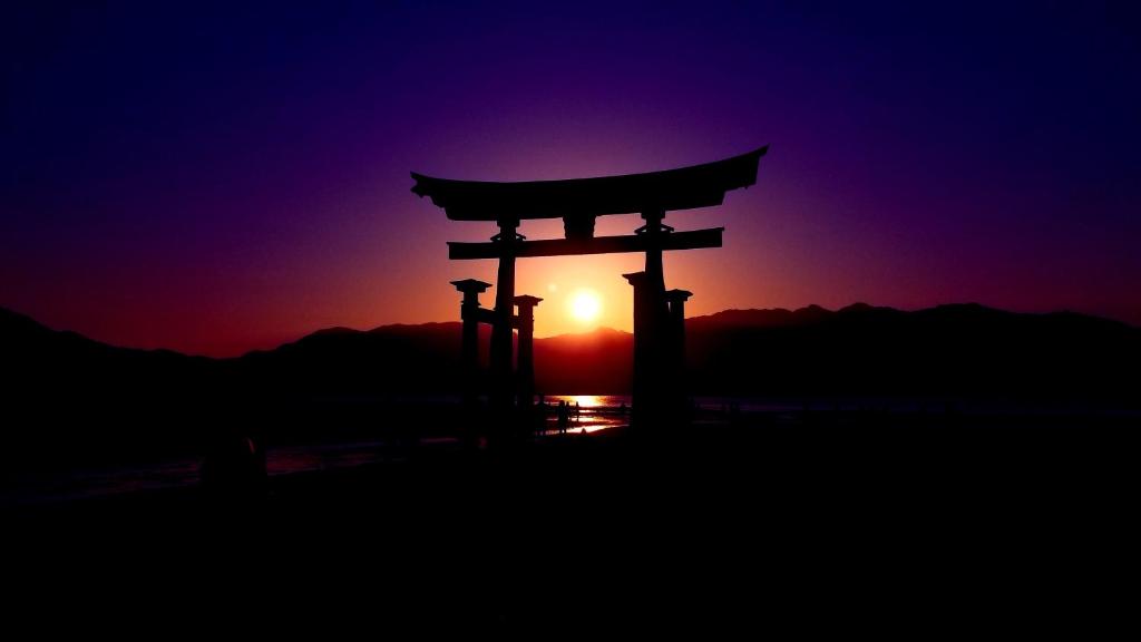 une porte asiatique devant un coucher de soleil dans l'établissement Full house Miyajima, à Miyajima