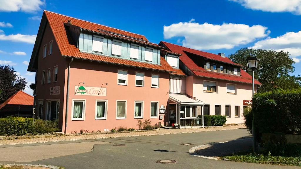 ein großes Gebäude mit rotem Dach auf einer Straße in der Unterkunft Gasthaus Linde in Ingelfingen