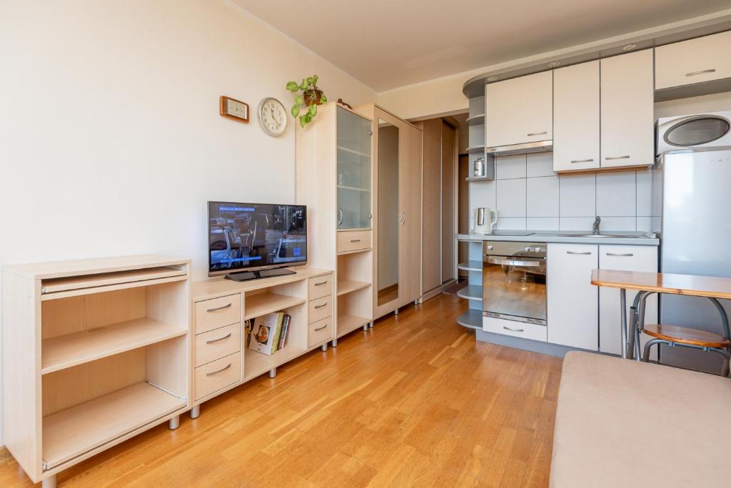 a kitchen with white cabinets and a wooden floor at Butas Nidos centre in Nida