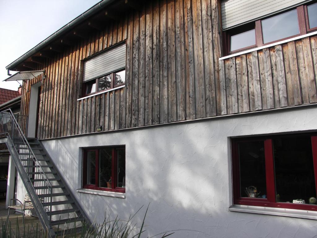 dom z drewnianą ścianą i dwoma oknami w obiekcie Ferienwohnung Mattheiser Weiher w Trewirze
