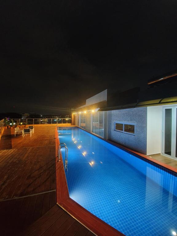 Santai Homestay Batam في باتام سنتر: مسبح على سطح مبنى في الليل