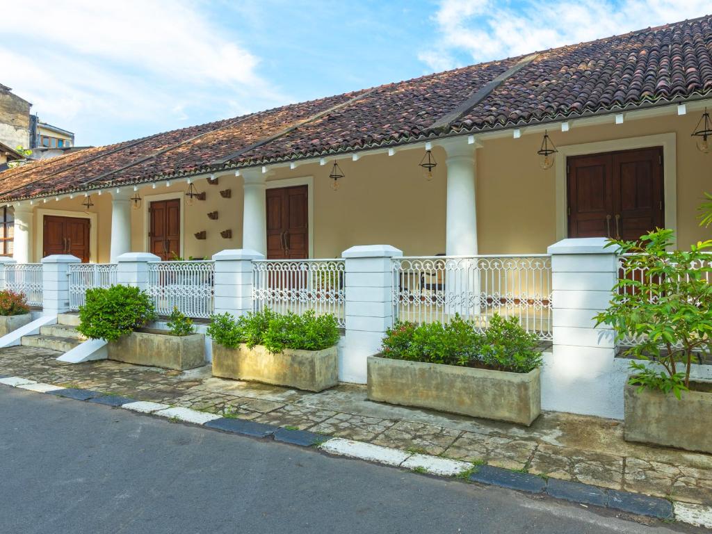 una casa con una cerca blanca y algunas plantas en Heritage Boutique, en Kandy