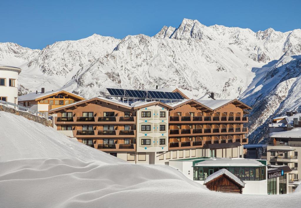 un complejo con montañas cubiertas de nieve en el fondo en Hotel Edelweiss Hochsölden Superior en Sölden