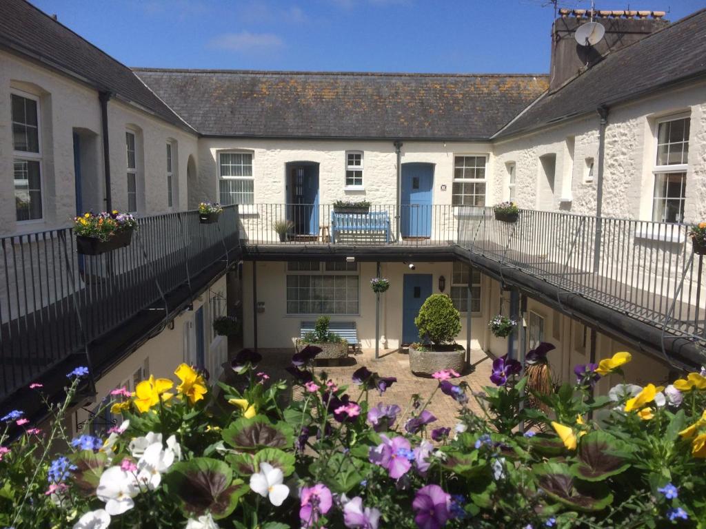 a courtyard of a house with flowers at Picturesque Mews Apartment Perfect Location Steps From Harbour and Beaches in Torquay