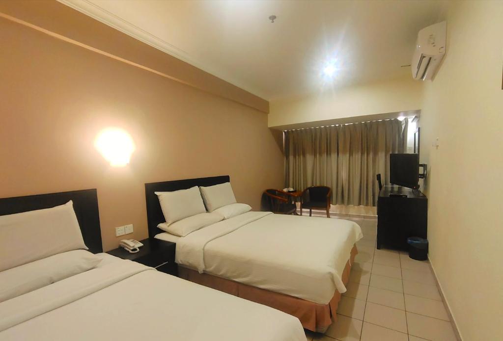 Postel nebo postele na pokoji v ubytování Megah D'aru Hotel