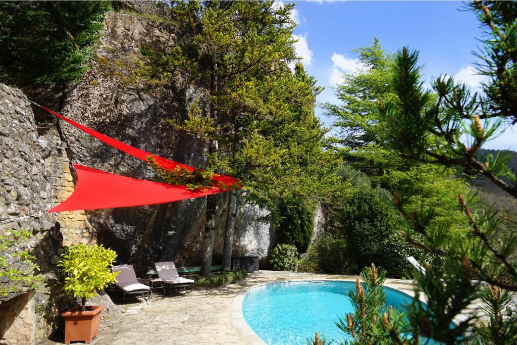 a house with a pool and a red flag at Le Colombier Saint-Véran in La Roque-Sainte-Marguerite