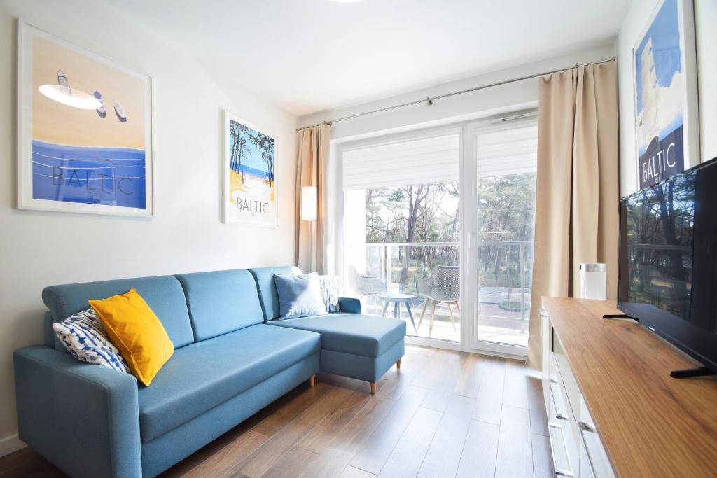 隱海市的住宿－DWIE SOSNY Baltic 35，客厅配有蓝色的沙发和电视
