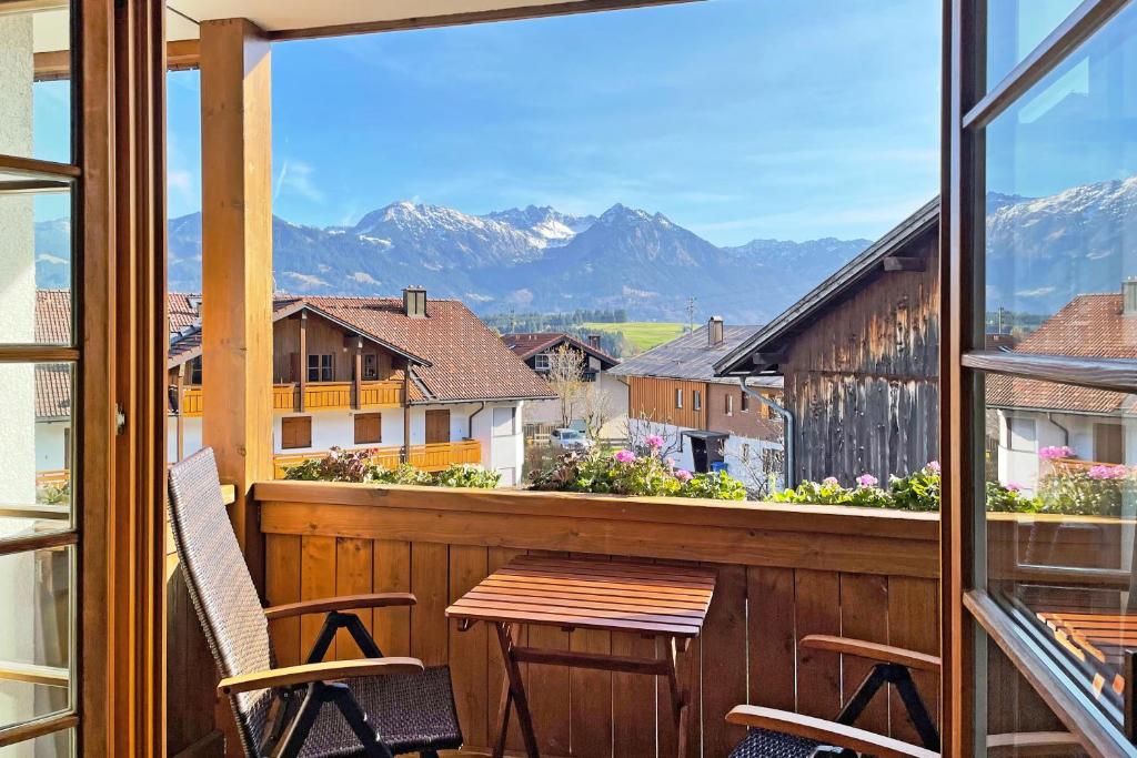 a balcony with a table and chairs and mountains at Alpenkönig in Bolsterlang
