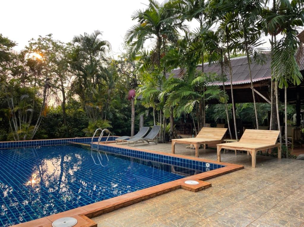 - une piscine avec 2 chaises et une maison dans l'établissement Bamboo Hideaway, Bungalows with Pool and Kitchen, à Ko Mak
