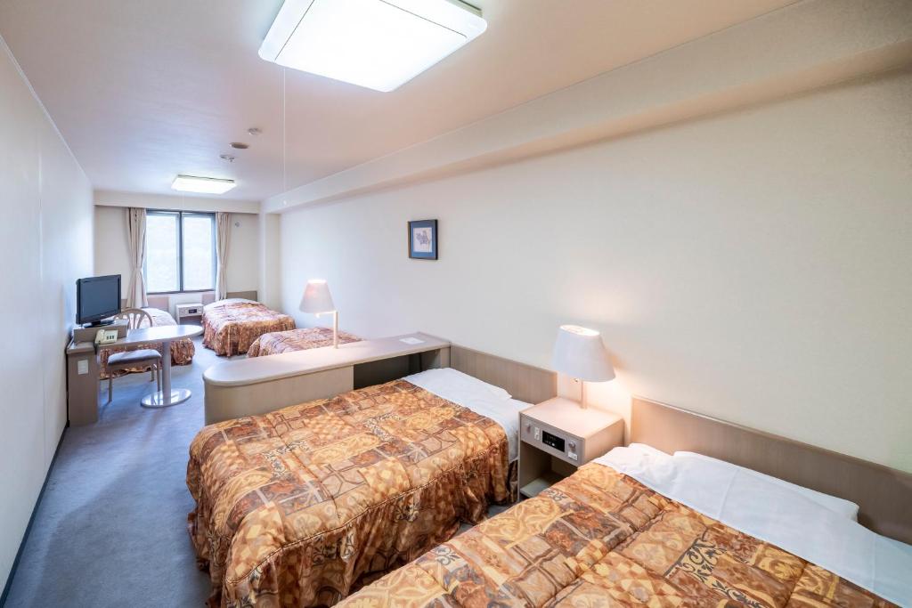 Postel nebo postele na pokoji v ubytování Hotel Tagawa