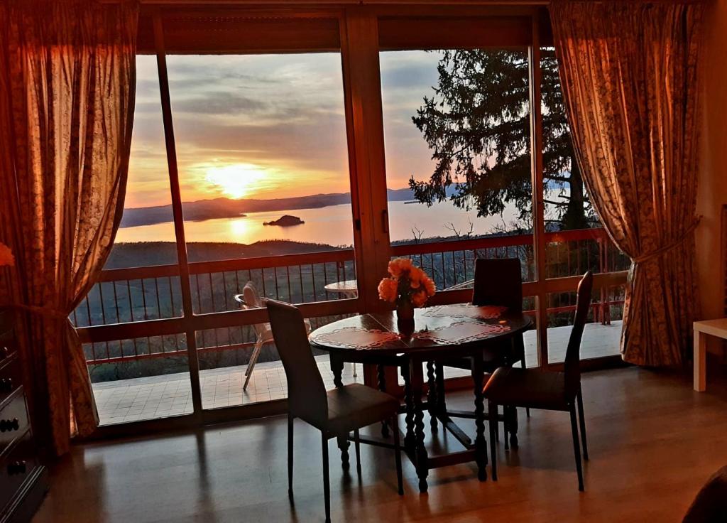 a dining room table with a view of the sunset at Belvedere del Lago in Montefiascone