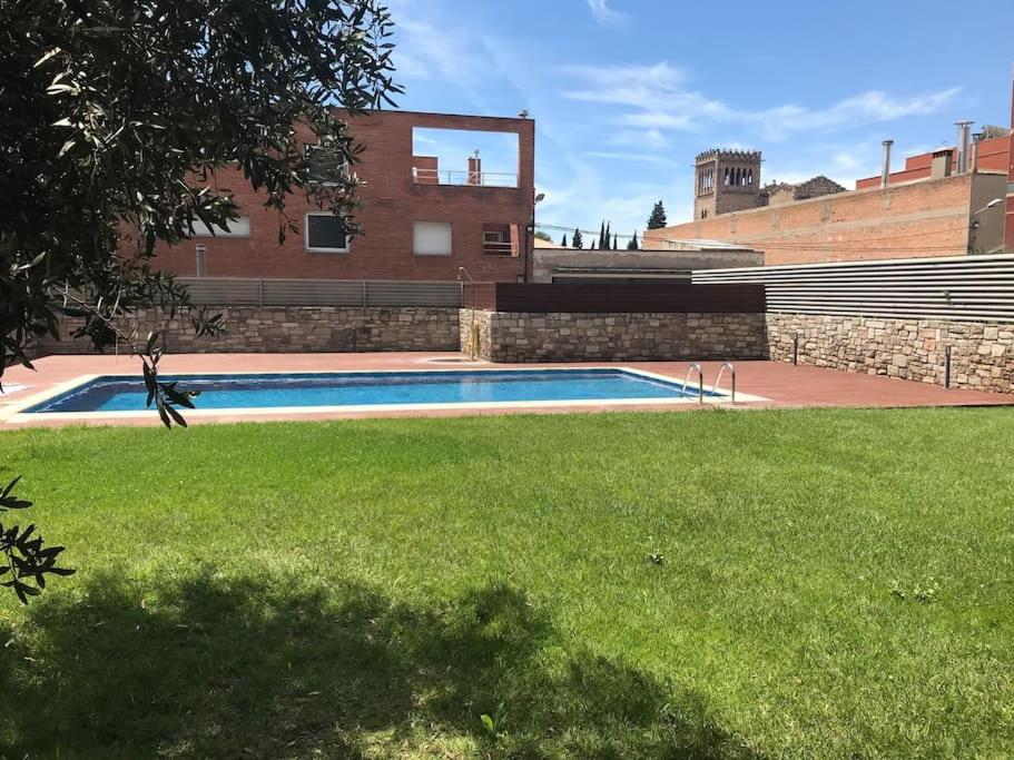 a swimming pool in the yard of a building at Apartamento con encanto in Igualada