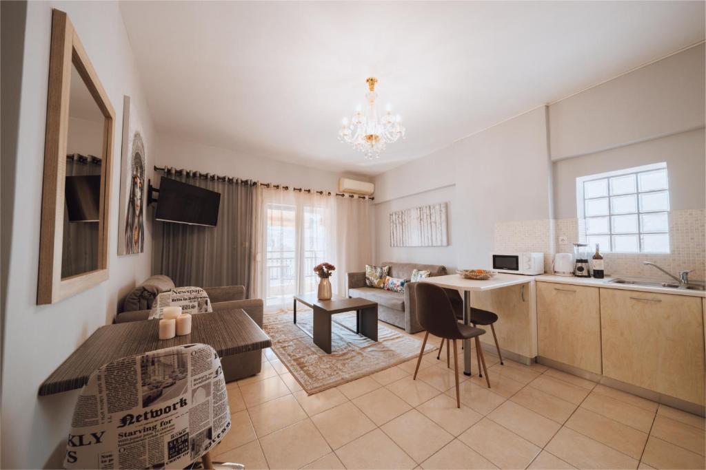 uma sala de estar e cozinha com um sofá e uma mesa em Iliotti Apartments in Ilha de Rhodes