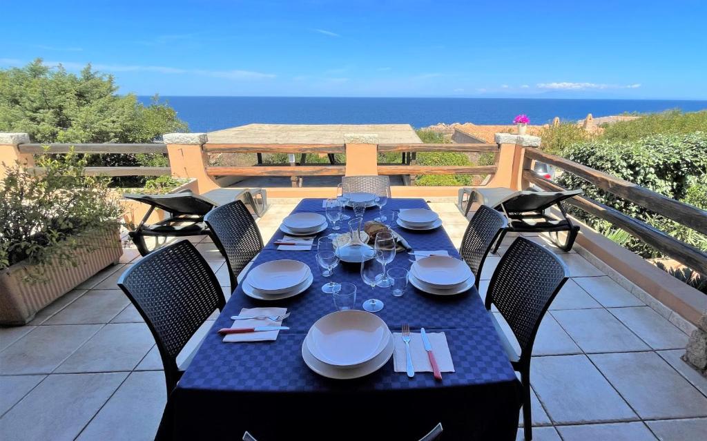uma mesa azul com cadeiras numa varanda com o oceano em Veranda sul Paradiso em Costa Paradiso