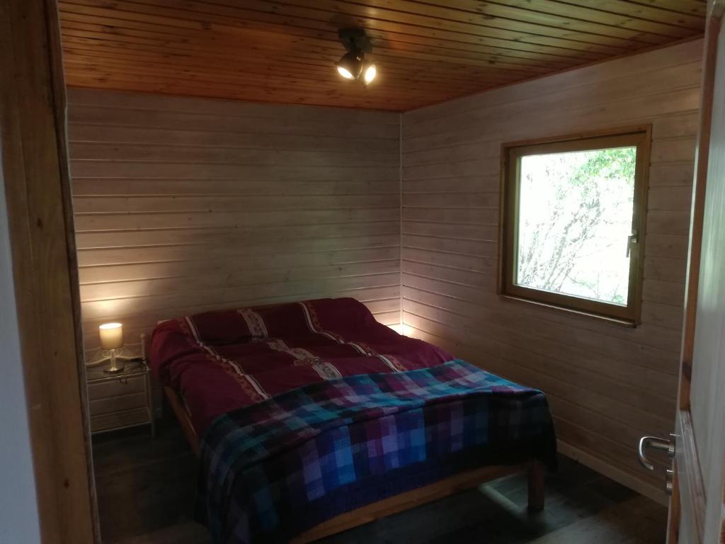 1 dormitorio pequeño con 1 cama en una habitación de madera en Hüttli en Rehburg-Loccum